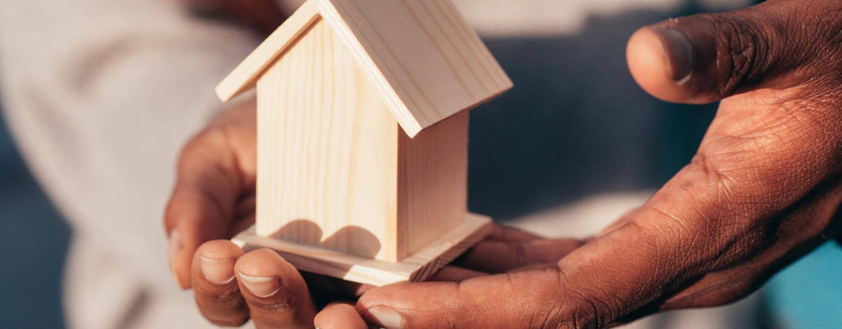A small wooden house held in hands