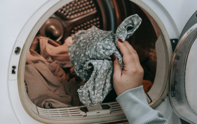 Unidentifiable person loading washing machine