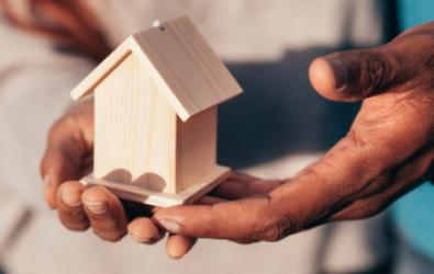 A small wooden house held in hands