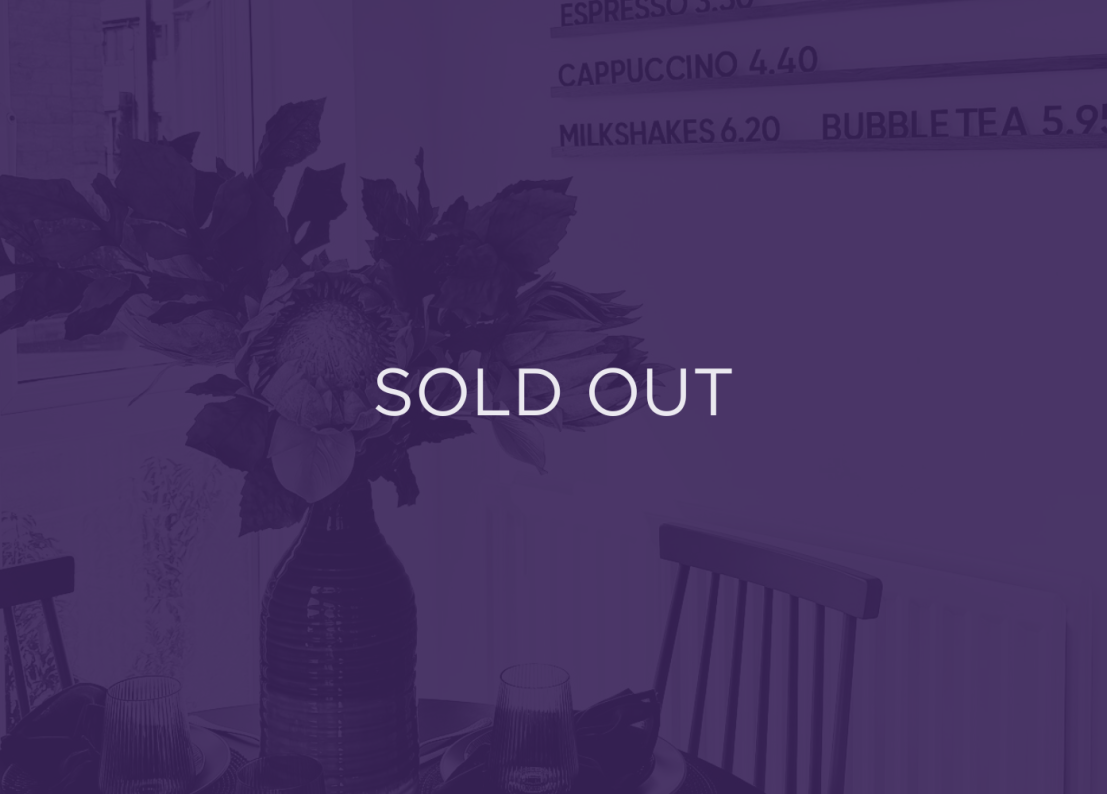 an image of flowers on a dining table, with a purple overlay and text that says sold out
